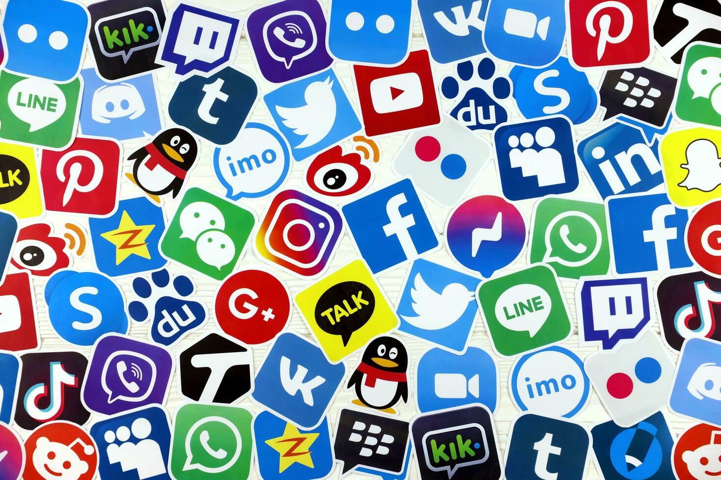 KHARKOV, UKRAINE - DECEMBER 26, 2020 Paper logos of most popular social networks and mobile messengers on wooden background. Facebook instagram youtube twitter tiktok twitch reddit etc. photo