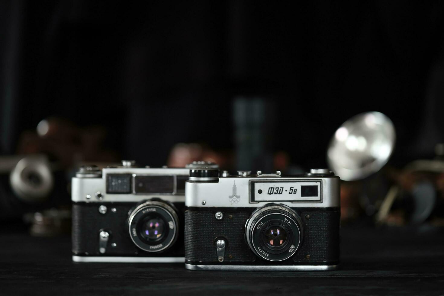 KHARKOV, UKRAINE - APRIL 27, 2021 Fed 4 and 5b Film photo camera and another old retro photo equipment on black wooden table in photographer darkroom. Photographic gear from soviet union