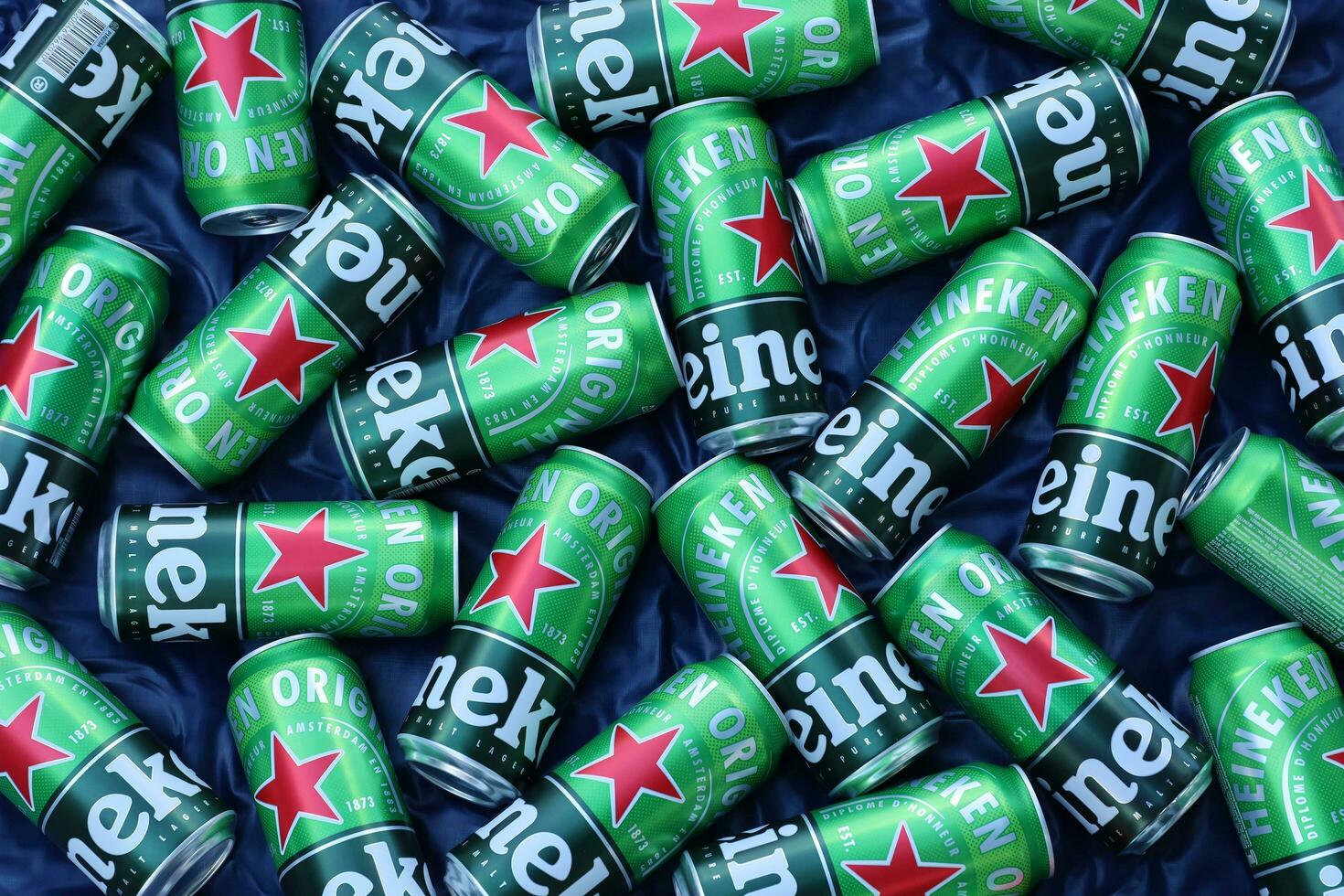 KHARKOV, UKRAINE - JULY 31, 2021 Green tin cans of Heineken lager beer produced by the Dutch brewing company Heineken N.V. photo