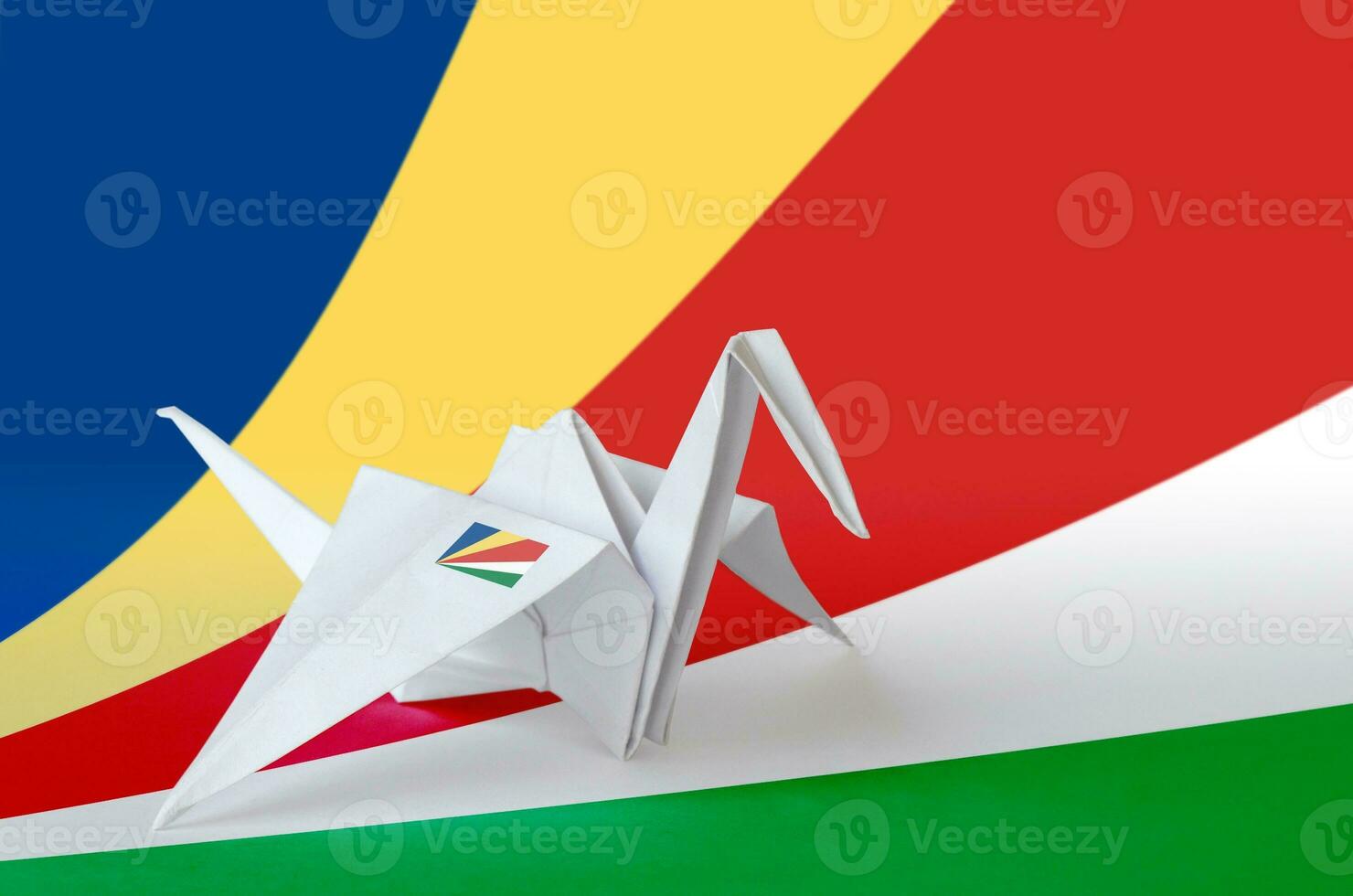 Seychelles flag depicted on paper origami crane wing. Handmade arts concept photo