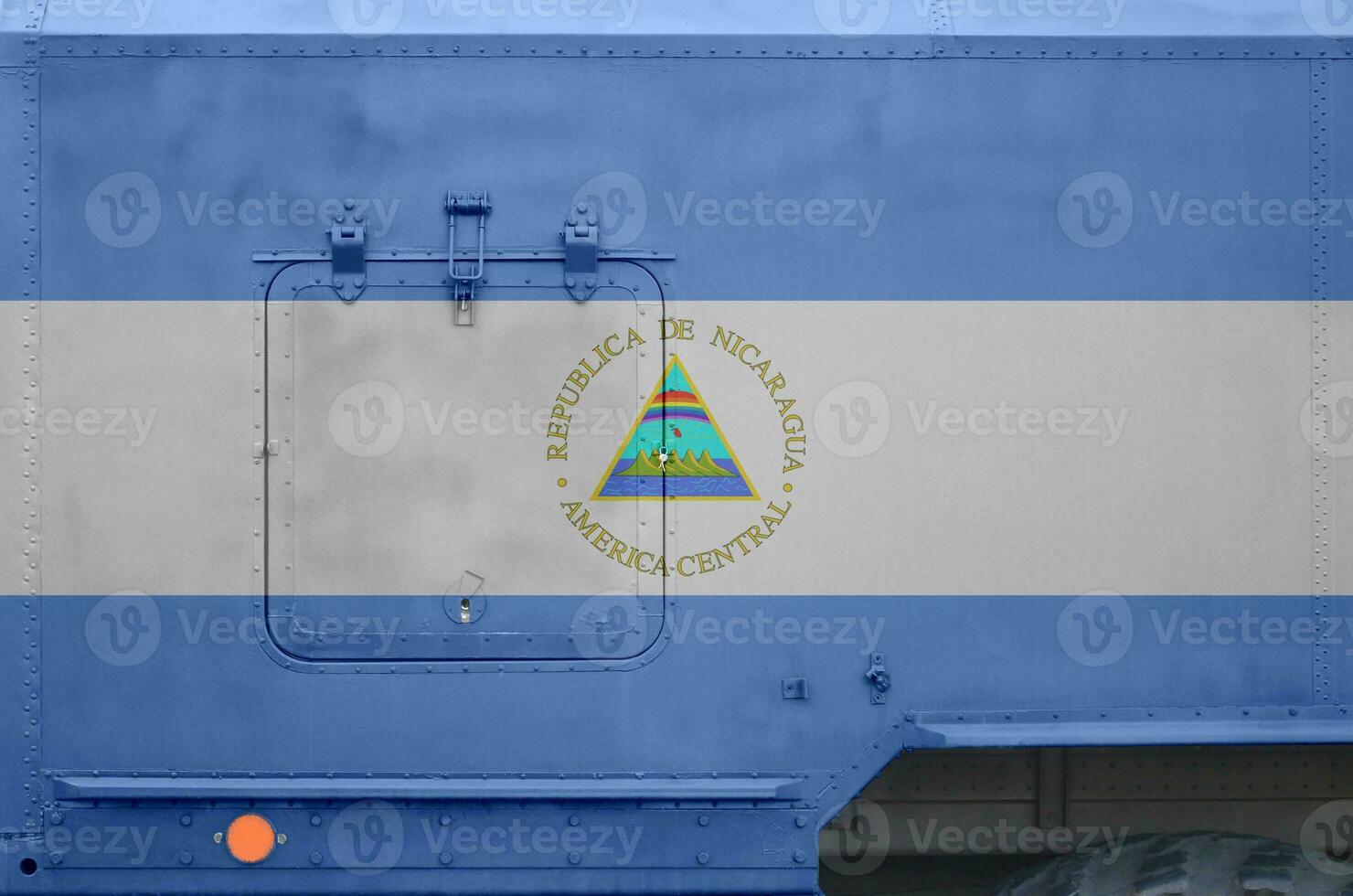 Nicaragua flag depicted on side part of military armored truck closeup. Army forces conceptual background photo