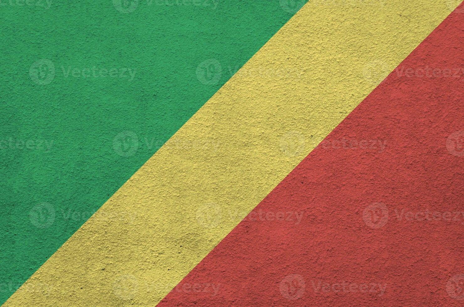 Congo flag depicted in bright paint colors on old relief plastering wall. Textured banner on rough background photo