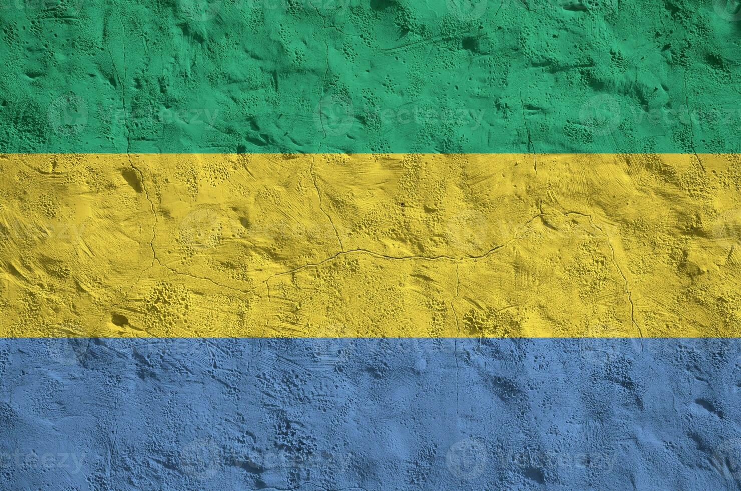 Gabon flag depicted in bright paint colors on old relief plastering wall. Textured banner on rough background photo