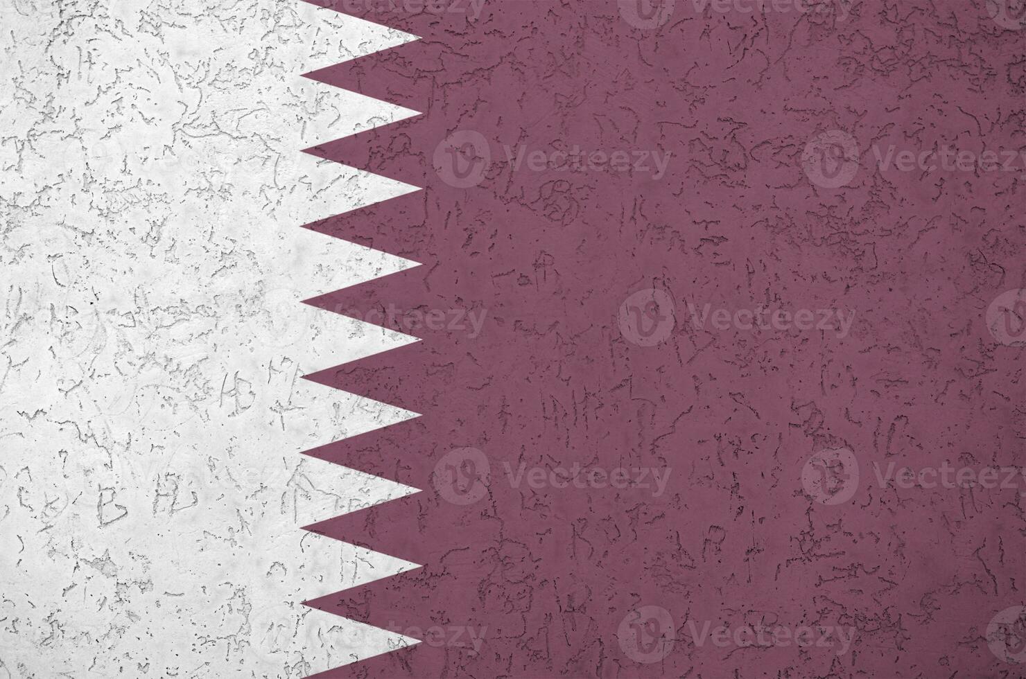 Qatar flag depicted in bright paint colors on old relief plastering wall. Textured banner on rough background photo