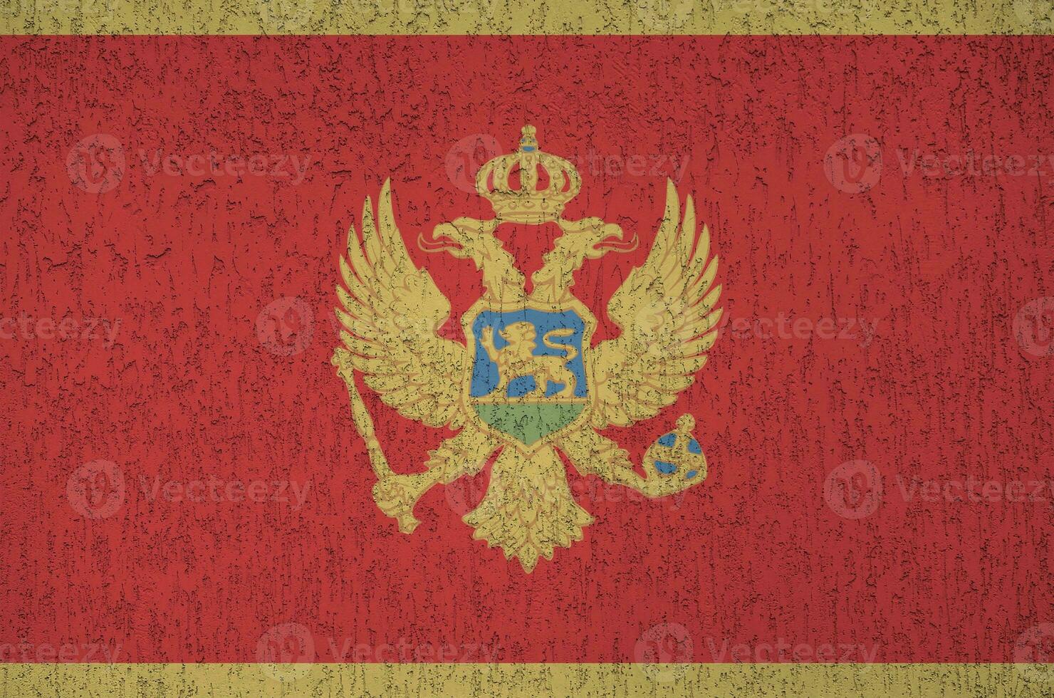 Montenegro flag depicted in bright paint colors on old relief plastering wall. Textured banner on rough background photo