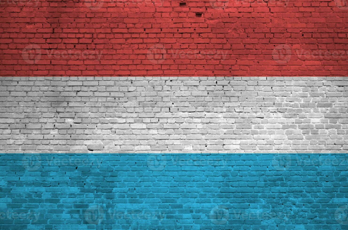 Luxembourg flag depicted in paint colors on old brick wall. Textured banner on big brick wall masonry background photo