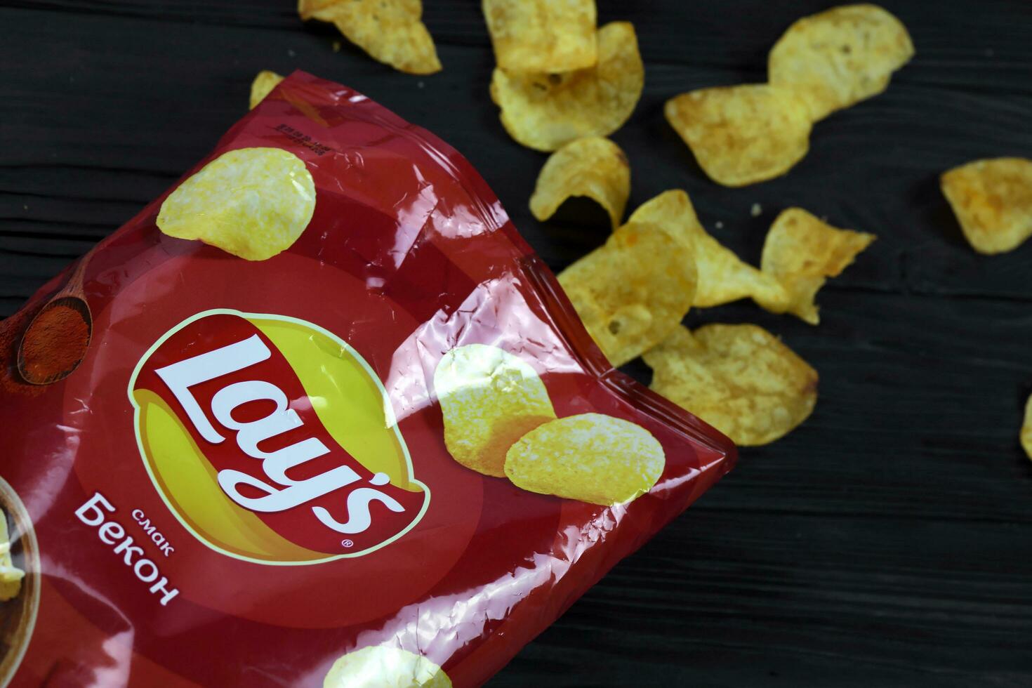 KHARKOV, UKRAINE - JANUARY 3, 2021 Lays potato chips with bacon flavour and original lays logo in middle of package. Worldwide famous brand of potato chips photo