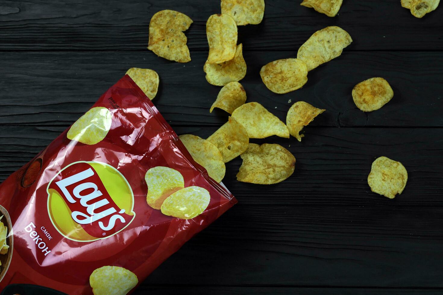 KHARKOV, UKRAINE - JANUARY 3, 2021 Lays potato chips with bacon flavour and original lays logo in middle of package. Worldwide famous brand of potato chips photo