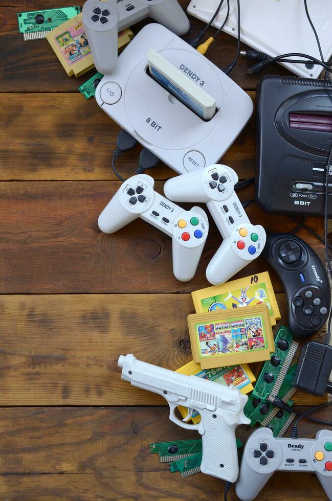 Old 8-bit video game console and many gaming accessories like a joysticks and cartridges photo