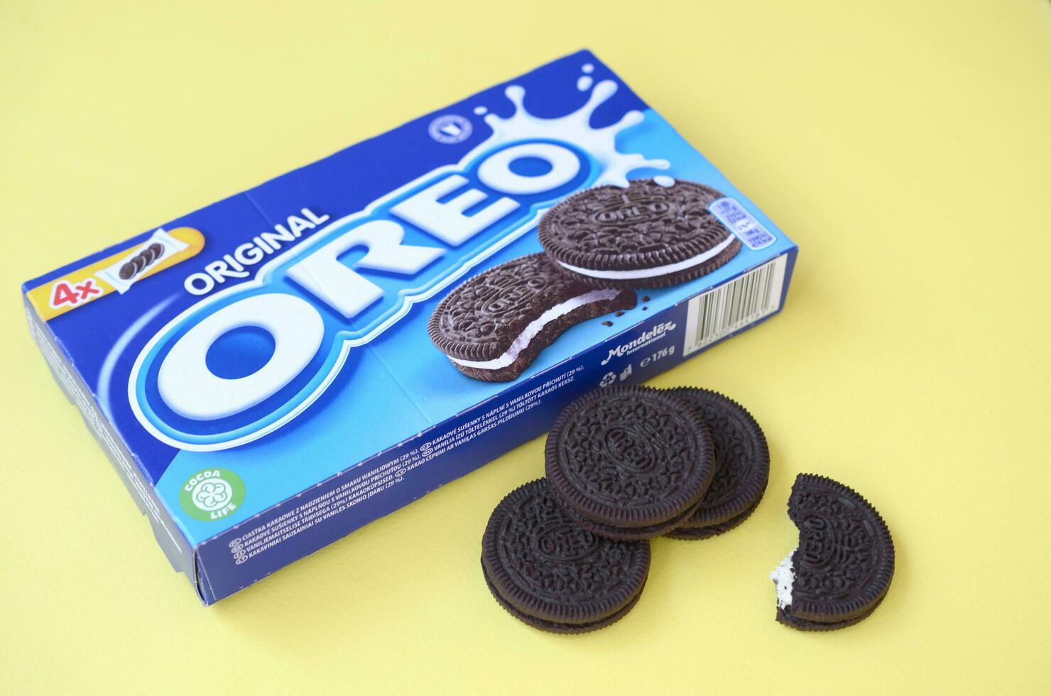 Many OREO sandwich cream biscuits with pack on yellow background photo