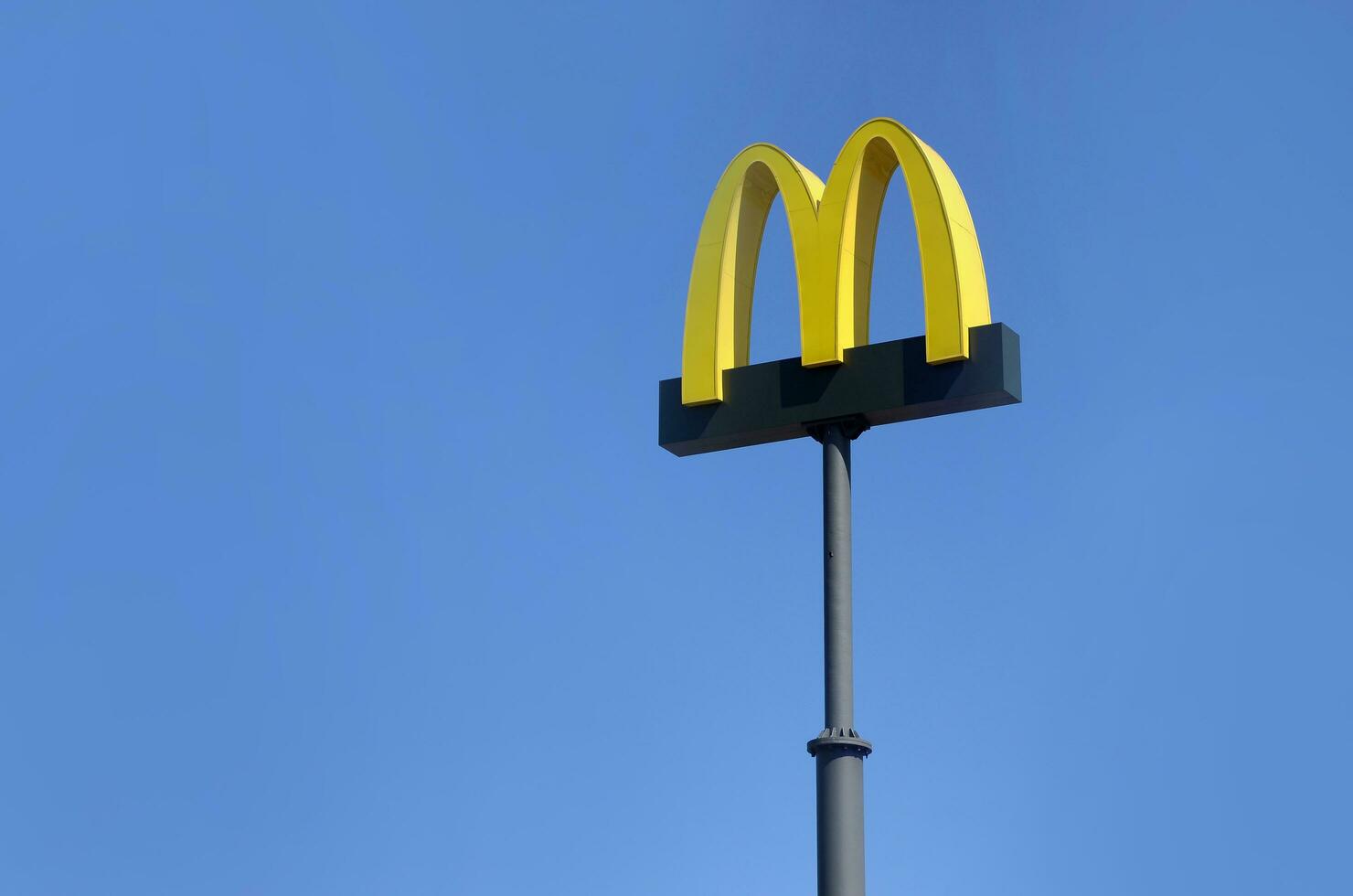 McDonalds yellow big logo on blue sky background photo