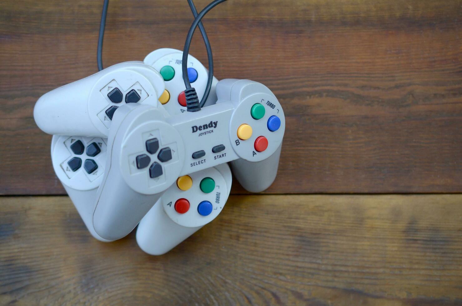 Dendy video game console classic controllers on a wooden table photo