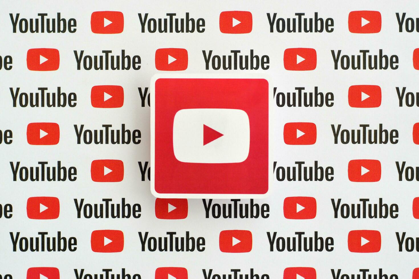 Youtube logo sticker on pattern printed on paper with small youtube logos and inscriptions. YouTube is Google subsidiary and American most popular video-sharing platform photo