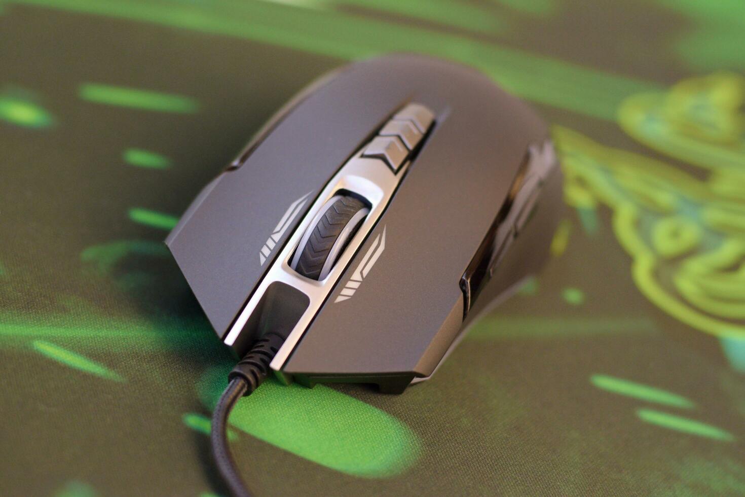 P93 Bloody cybersport gaming mouse by A4Tech lies on Razer Goliathus mouse pad. Professional cybersport supply photo