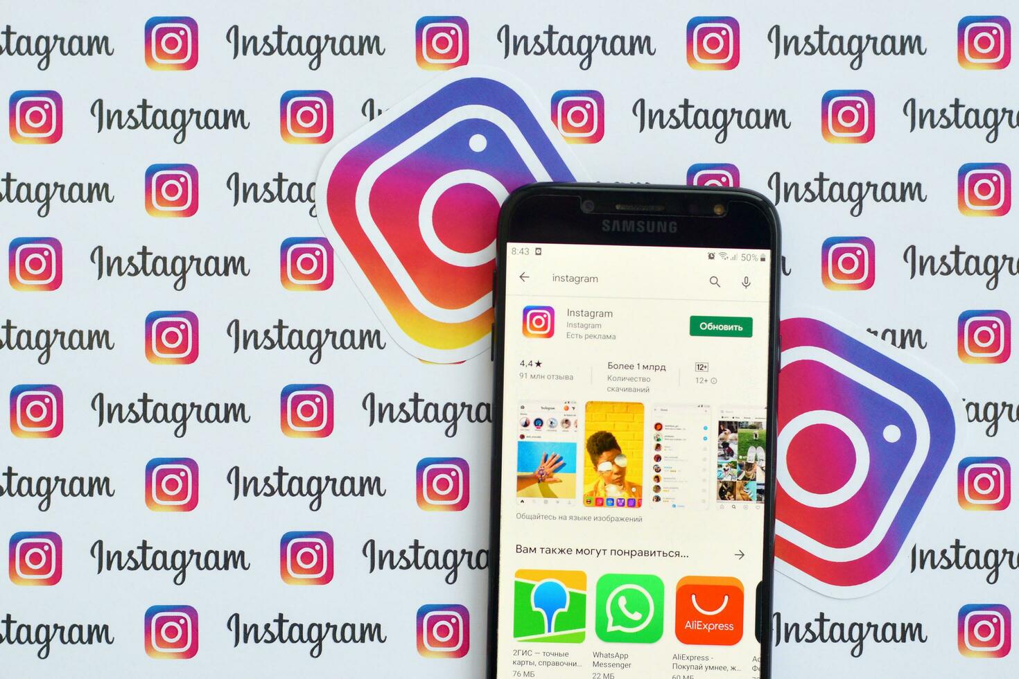Instagram app on samsung smartphone screen on banner with small instagram logos. Instagram is American photo and video-sharing social networking service by Facebook inc