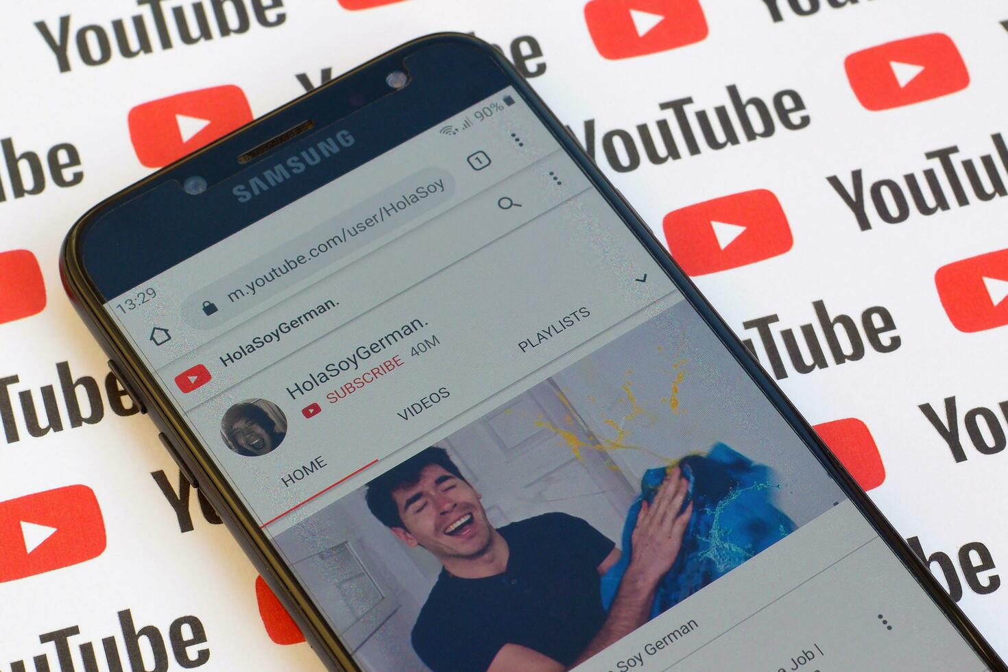 HolaSoyGerman official youtube channel on smartphone screen on paper youtube background. photo