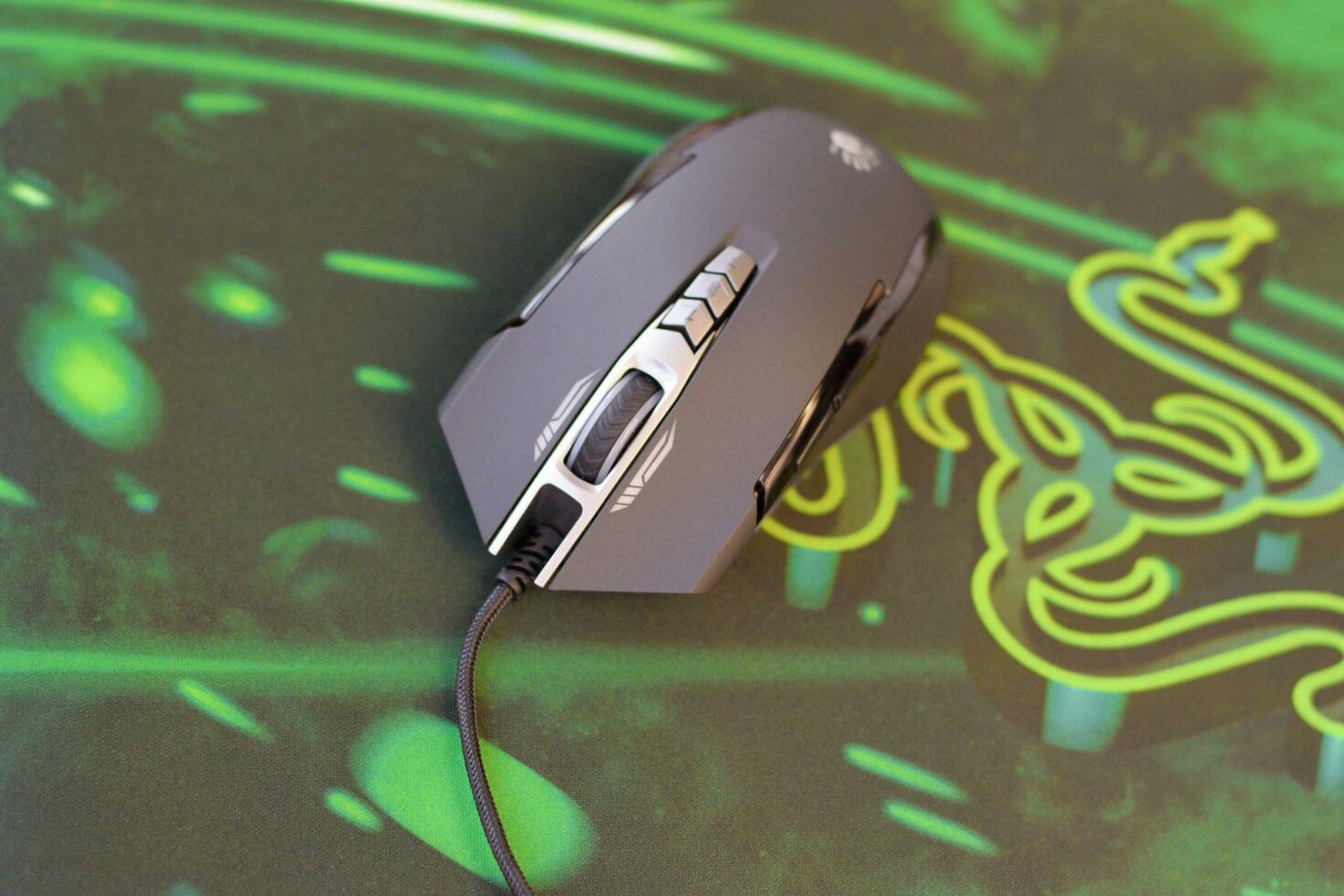 P93 Bloody cybersport gaming mouse by A4Tech lies on Razer Goliathus mouse pad. Professional cybersport supply photo