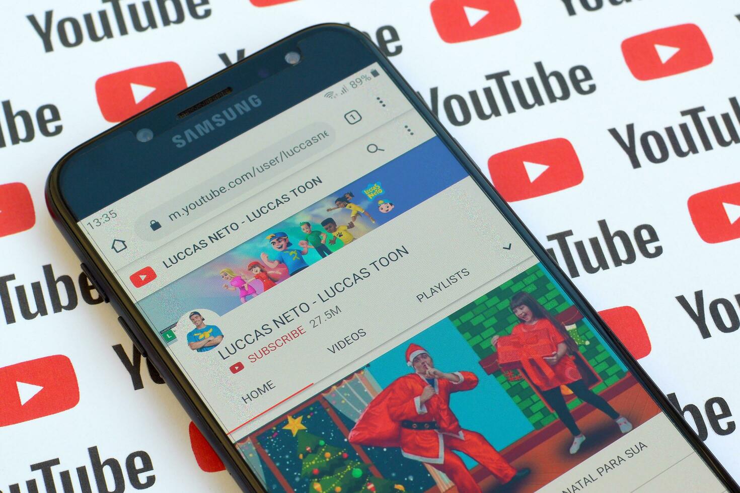 Luccas Neto - Luccas toon official youtube channel on smartphone screen on paper youtube background. photo