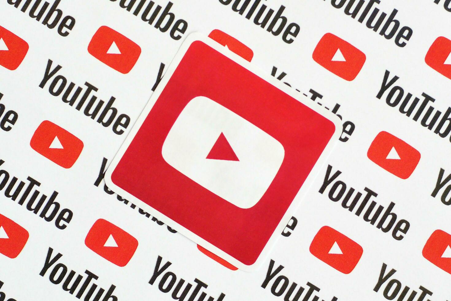 Youtube logo sticker on pattern printed on paper with small youtube logos and inscriptions. YouTube is Google subsidiary and American most popular video-sharing platform photo