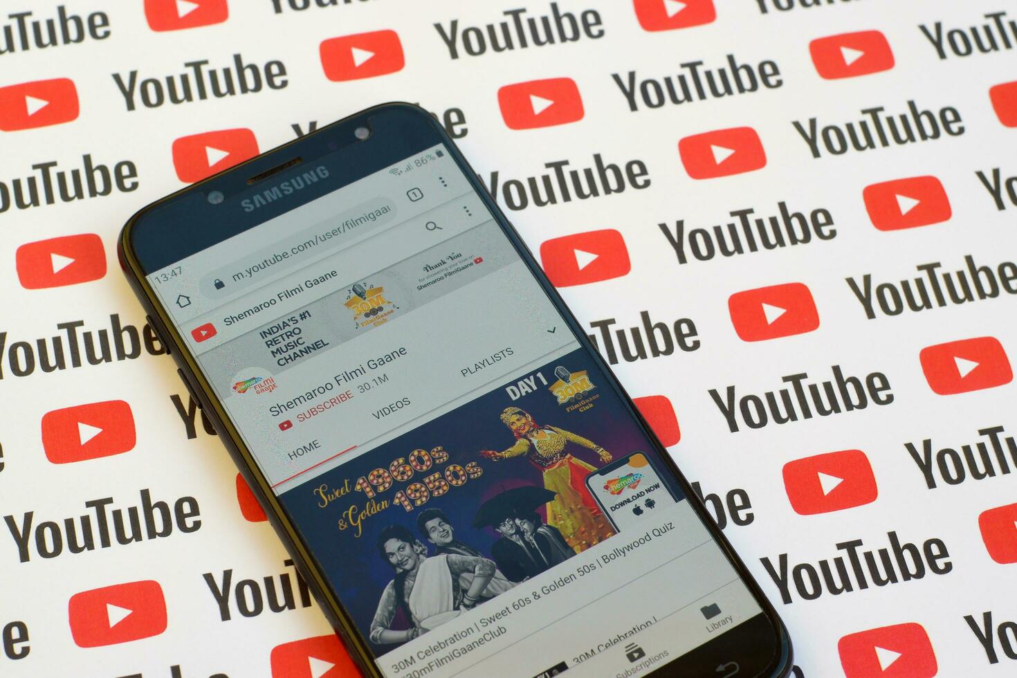 Shemaroo Filmi Gaane official youtube channel on smartphone screen on paper youtube background. photo