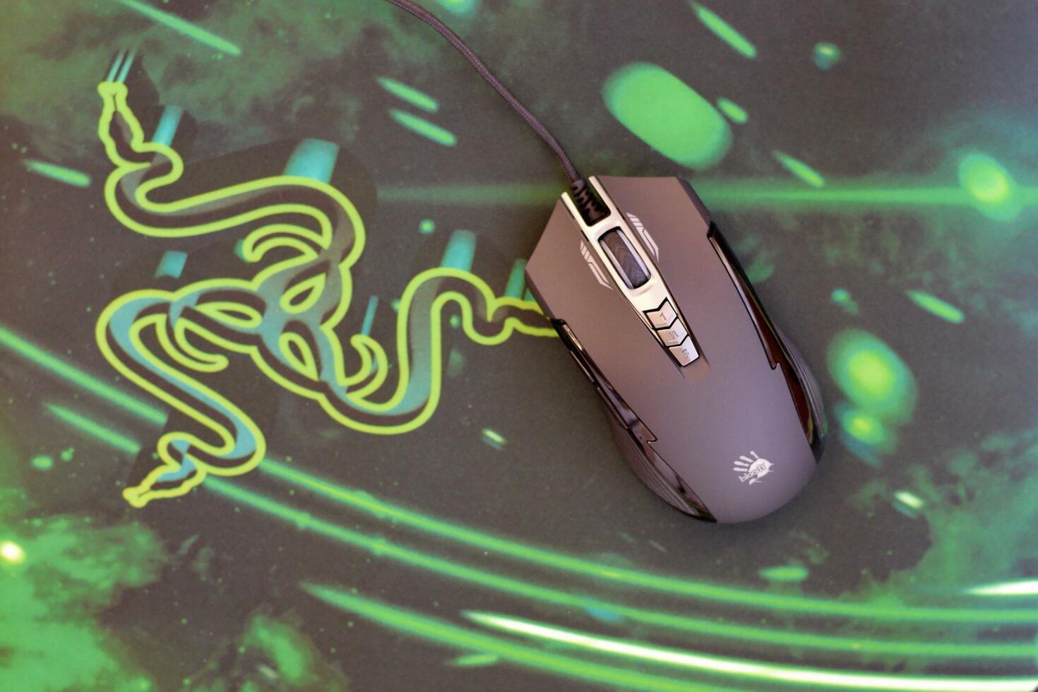 P93 Bloody cybersport gaming mouse by A4Tech lies on Razer Goliathus mouse pad. Professional cybersport supply photo