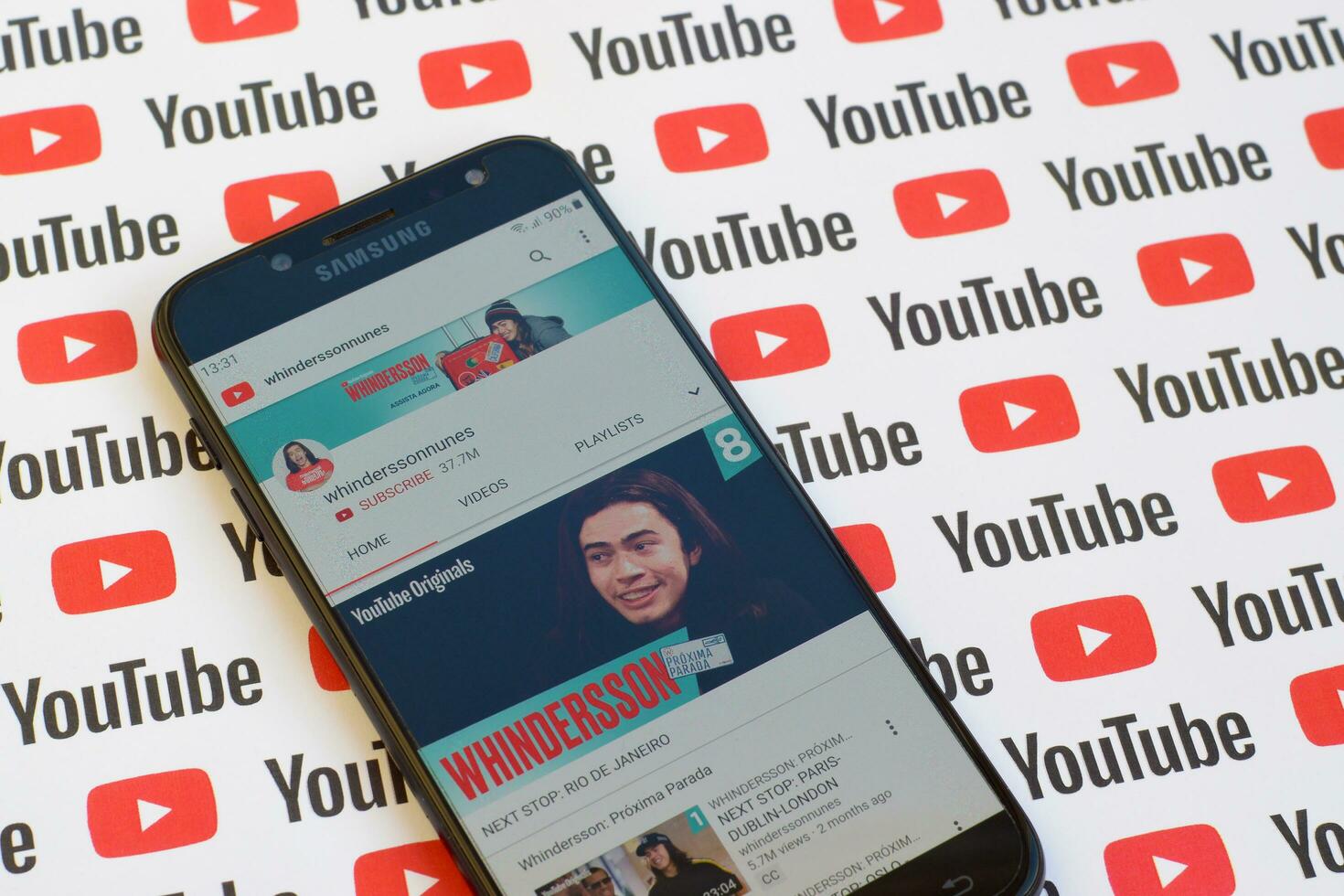 Whinderssonnunes official youtube channel on smartphone screen on paper youtube background. photo
