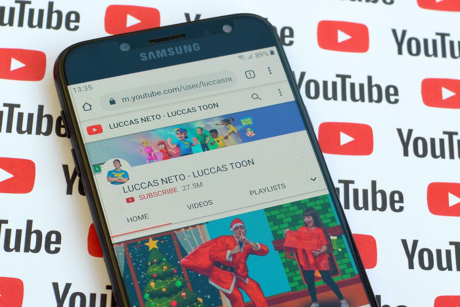 Luccas Neto - Luccas toon official youtube channel on smartphone screen on paper youtube background. photo