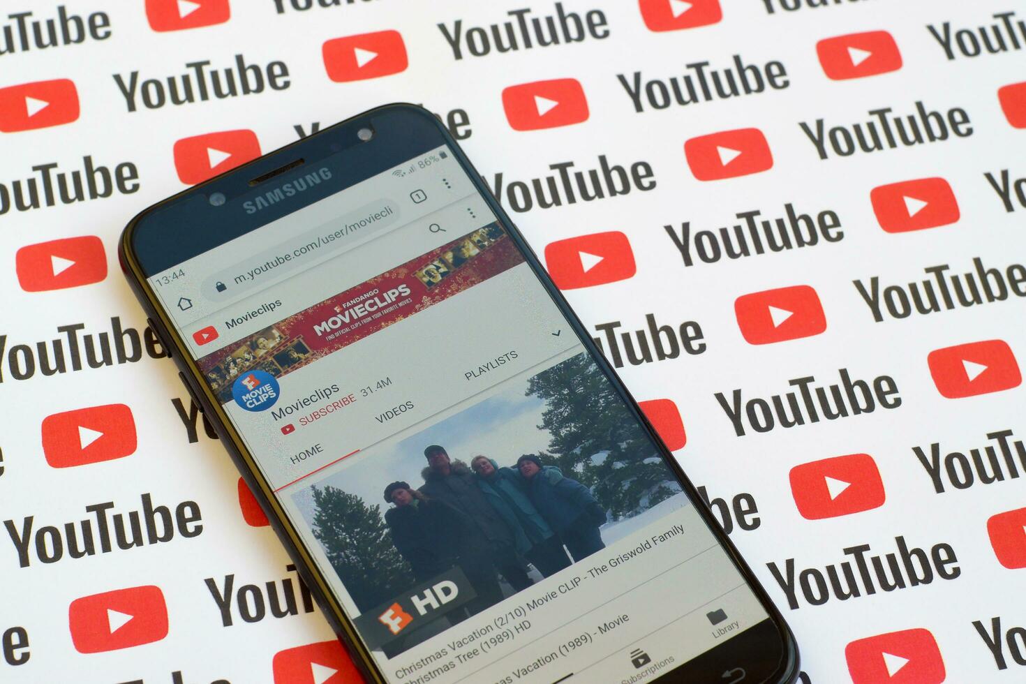 Movieclips official youtube channel on smartphone screen on paper youtube background. photo