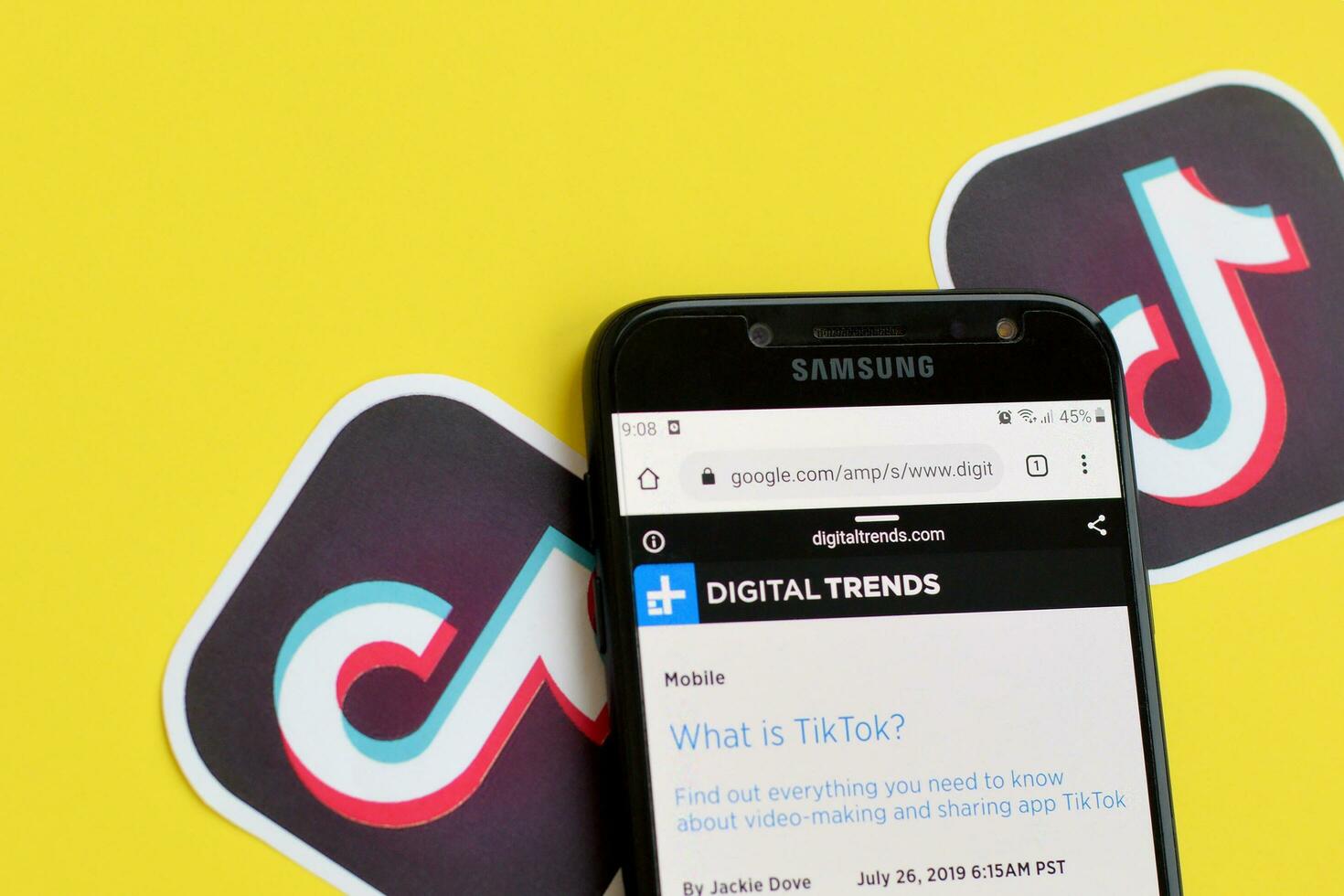 Topic about Tiktok on digitaltrends.com on samsung smartphone screen on yellow background. TikTok is a popular video-sharing social networking service owned by ByteDance photo