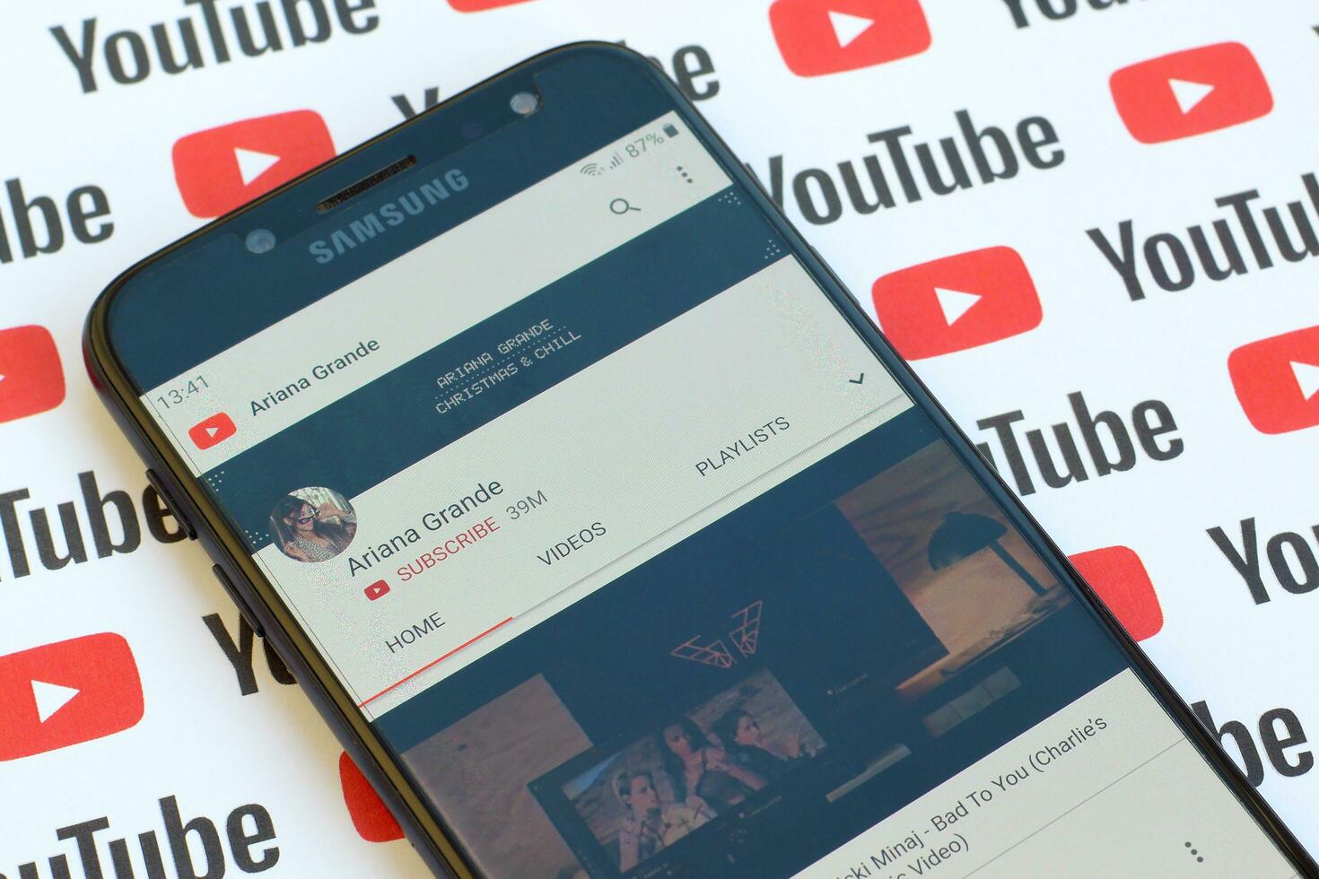 Ariana Grande official youtube channel on smartphone screen on paper youtube background. photo