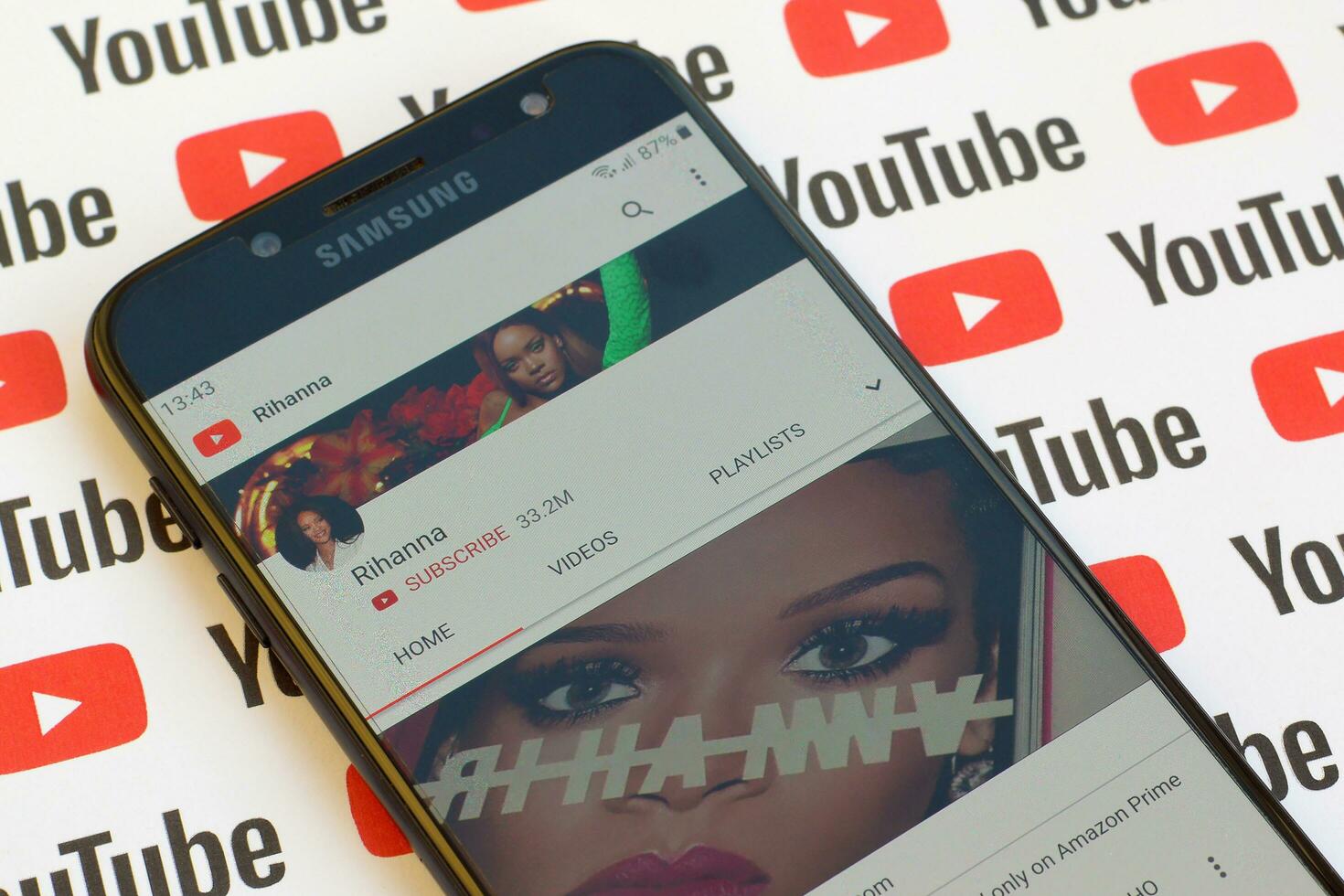 Rihanna official youtube channel on smartphone screen on paper youtube background. photo
