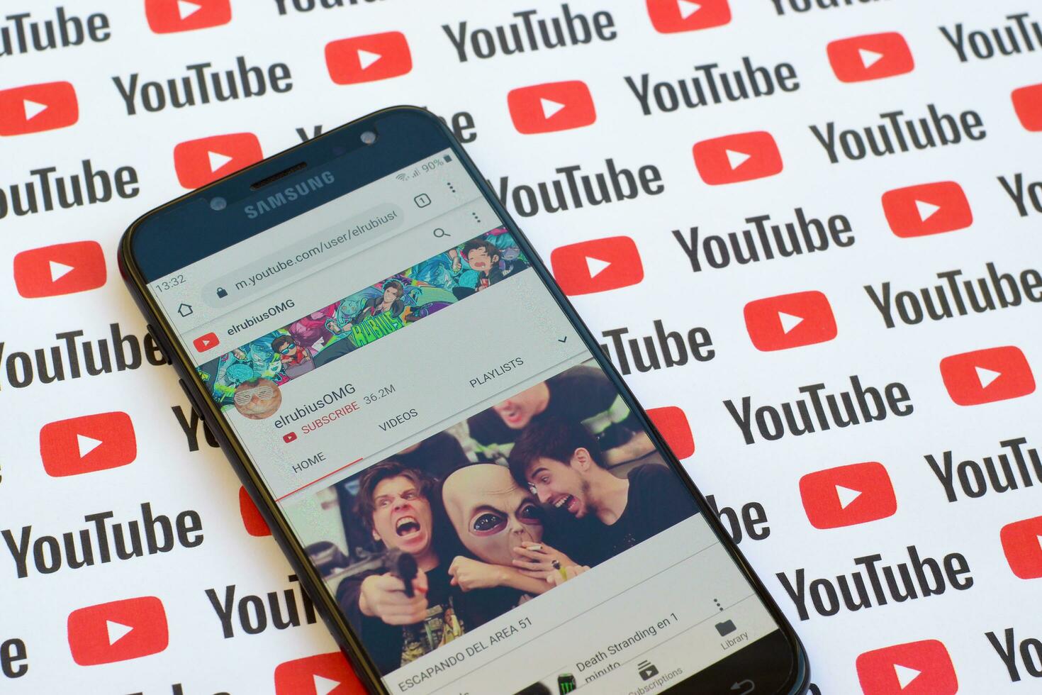 ElrubiusOMG official youtube channel on smartphone screen on paper youtube background. photo