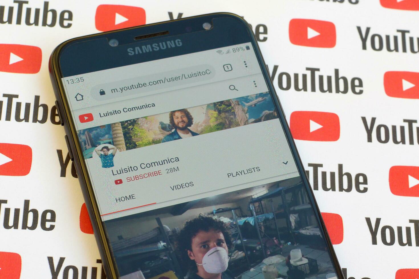 Luisito Comunica official youtube channel on smartphone screen on paper youtube background. photo