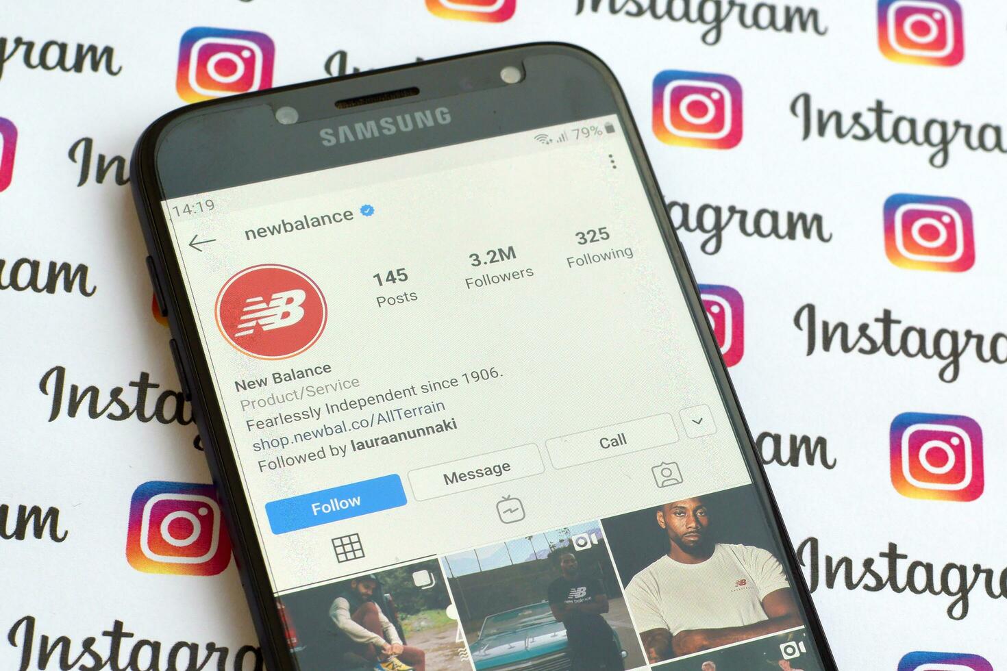 New Balance official instagram account on smartphone screen on paper instagram banner. photo