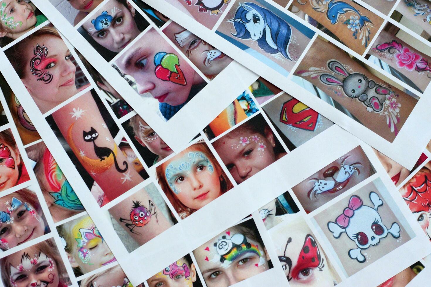 Many catalog pages with printed kids portraits with colorful face painting photo
