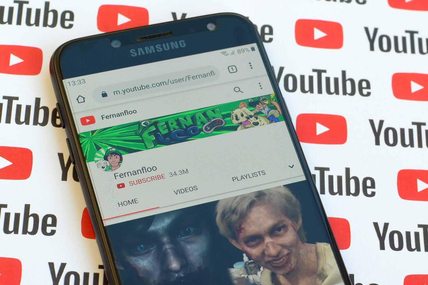 Fernanfloo official youtube channel on smartphone screen on paper youtube background. photo