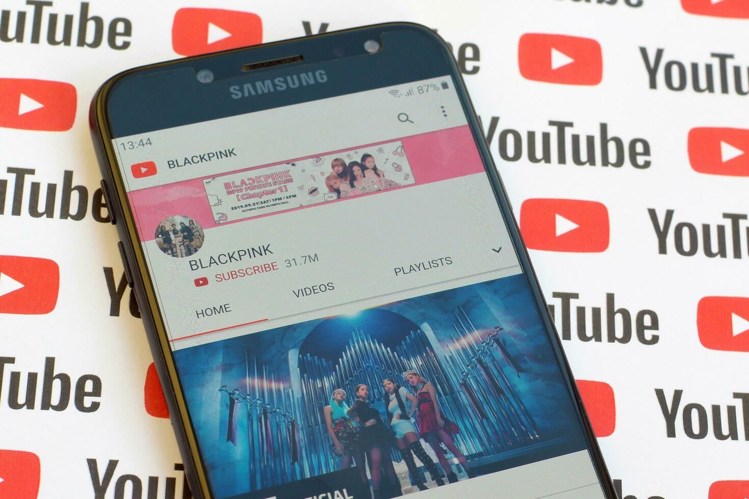 Blackpink official youtube channel on smartphone screen on paper youtube background. photo