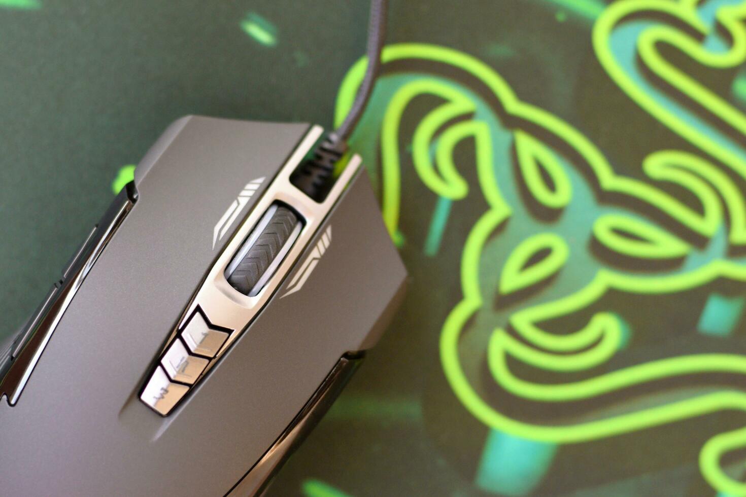 P93 Bloody cybersport gaming mouse by A4Tech lies on Razer Goliathus mouse pad. Professional cybersport supply photo