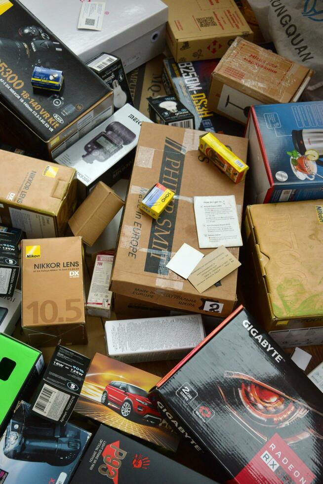 Big pile of many cardboard boxes from electronic products of famous manufacturers. Disposable wrappings of domestic use goods. Waste paper recycling photo