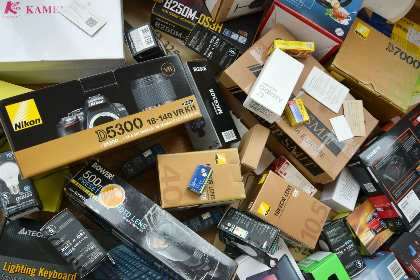 Big pile of many cardboard boxes from electronic products of famous manufacturers. Disposable wrappings of domestic use goods. Waste paper recycling photo