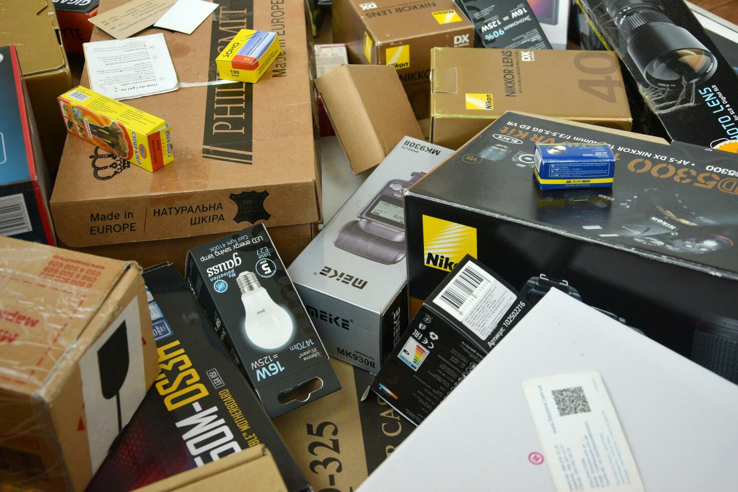 Big pile of many cardboard boxes from electronic products of famous manufacturers. Disposable wrappings of domestic use goods. Waste paper recycling photo