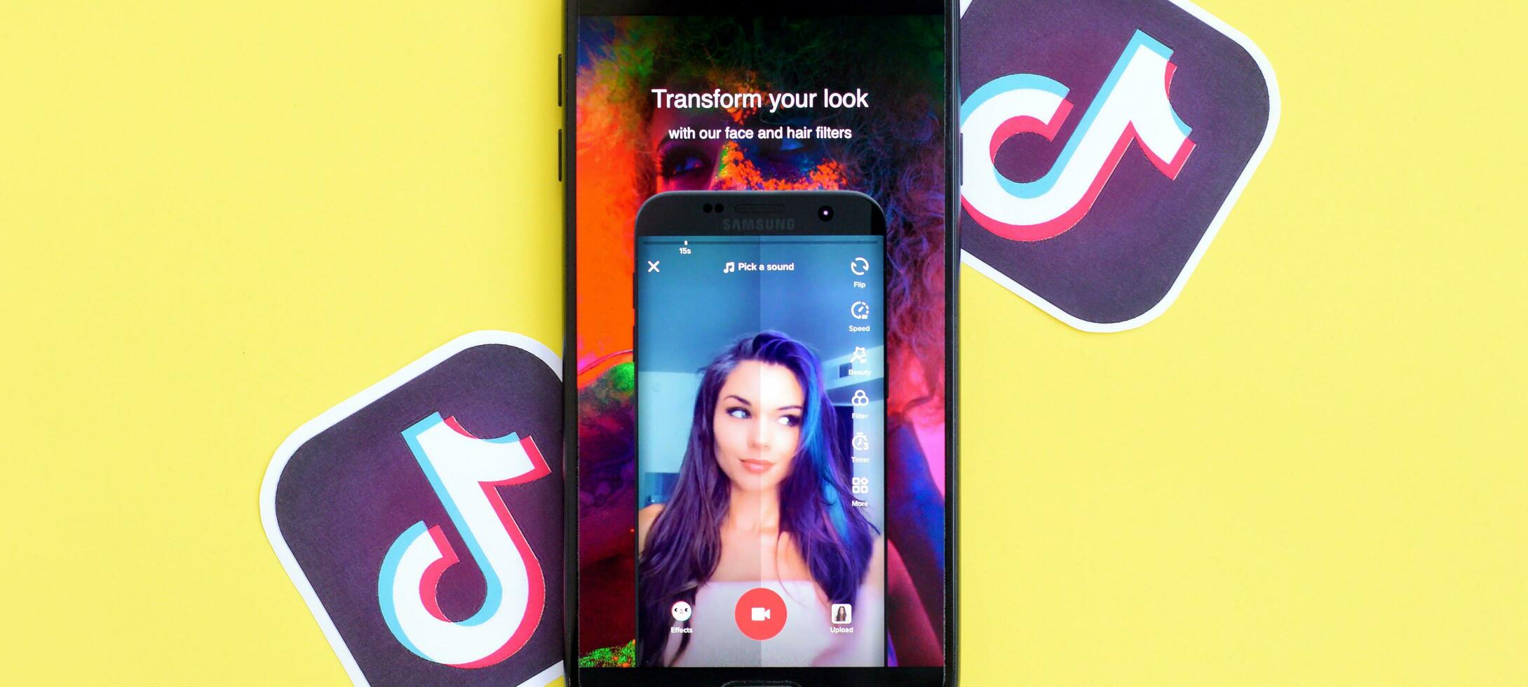 Tik Tok solicitud en Samsung teléfono inteligente pantalla en amarillo antecedentes. Tik Tok es un popular compartir videos social redes Servicio poseído por bytedance foto