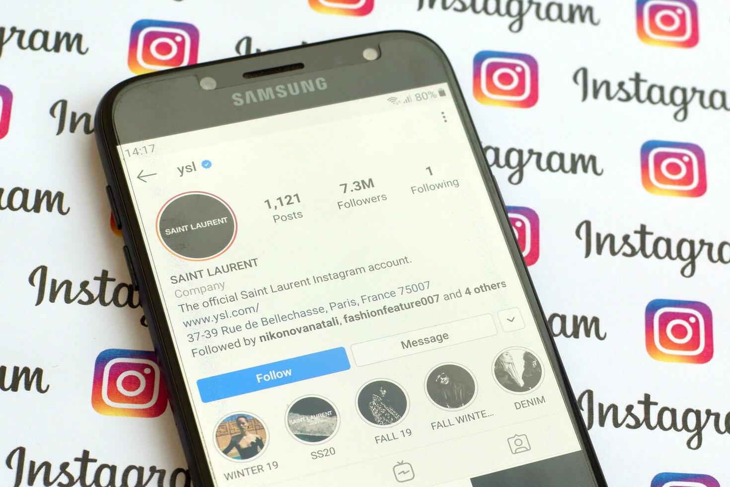 Yves Saint Laurent official instagram account on smartphone screen on paper instagram banner. photo