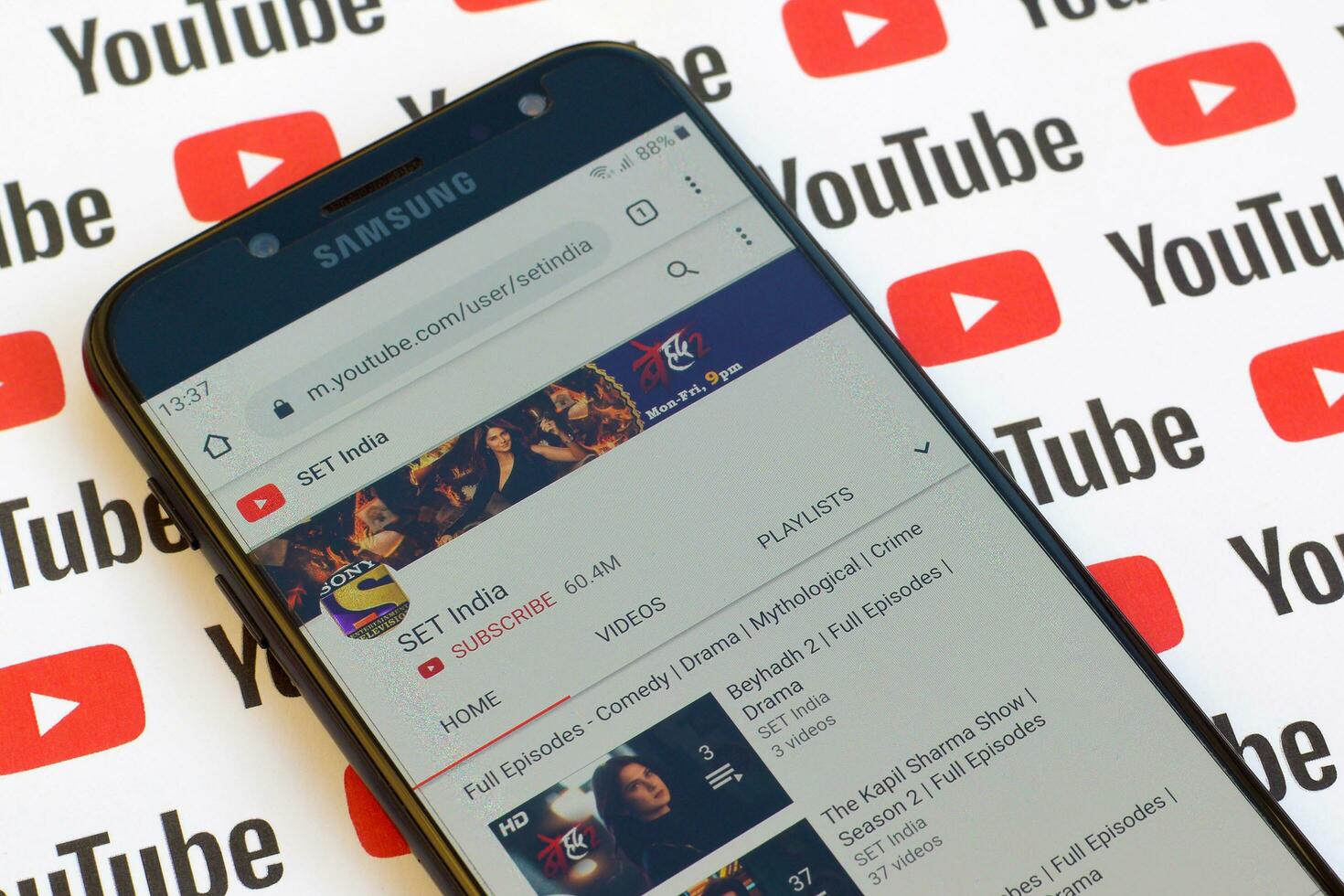 SET india official youtube channel on smartphone screen on paper youtube background. photo