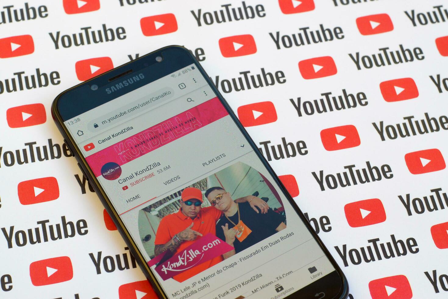 Canal KondZilla official youtube channel on smartphone screen on paper youtube background. photo