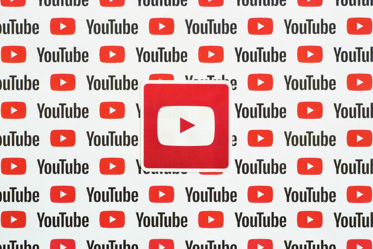 Youtube logo sticker on pattern printed on paper with small youtube logos and inscriptions. YouTube is Google subsidiary and American most popular video-sharing platform photo