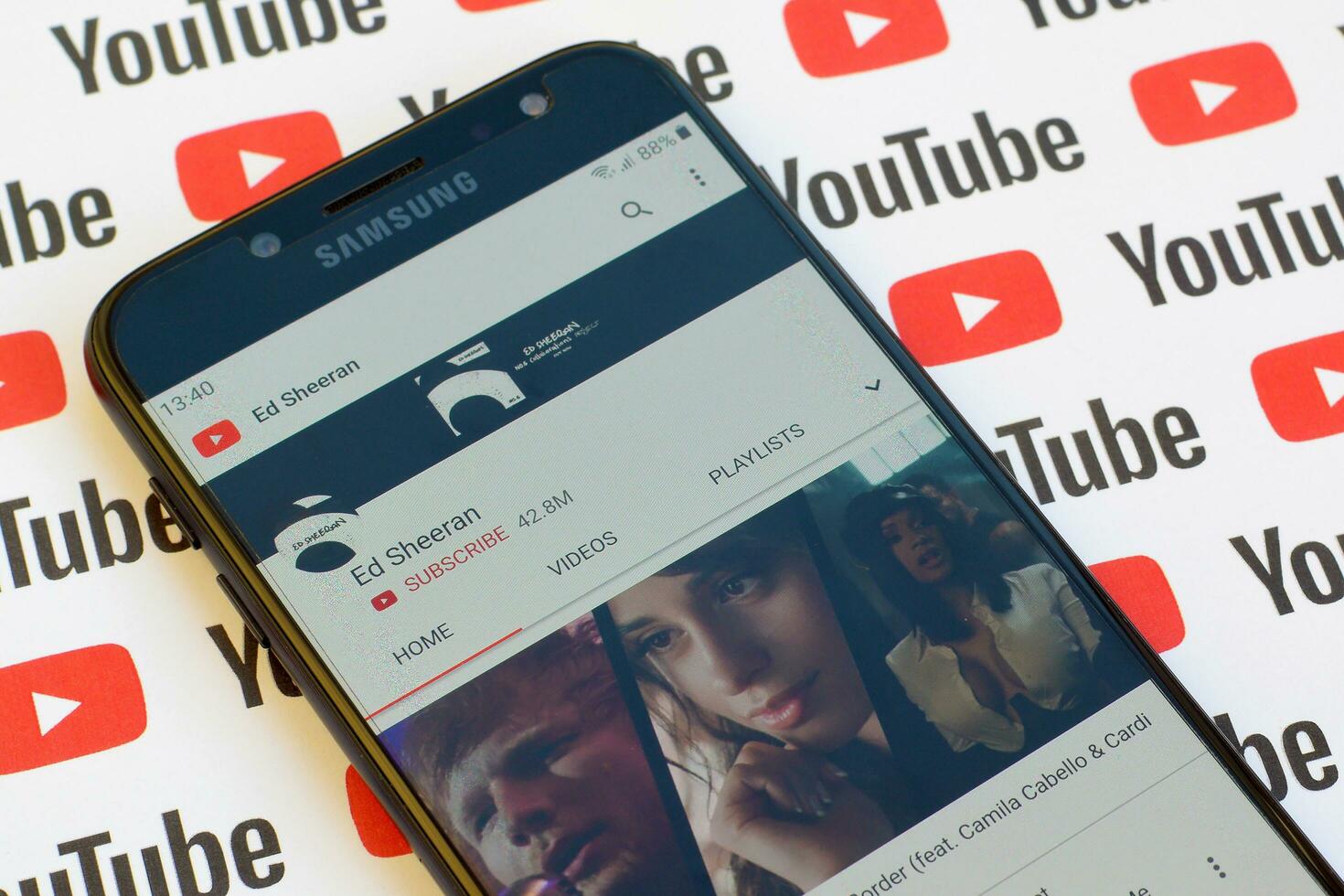 Ed Sheeran official youtube channel on smartphone screen on paper youtube background. photo