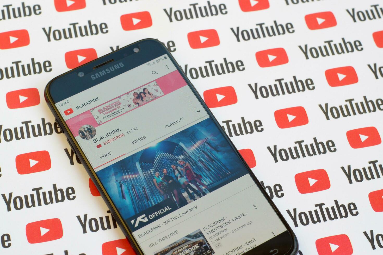 Blackpink official youtube channel on smartphone screen on paper youtube background. photo