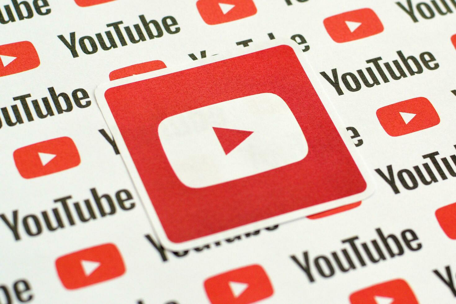 Youtube logo sticker on pattern printed on paper with small youtube logos and inscriptions. YouTube is Google subsidiary and American most popular video-sharing platform photo