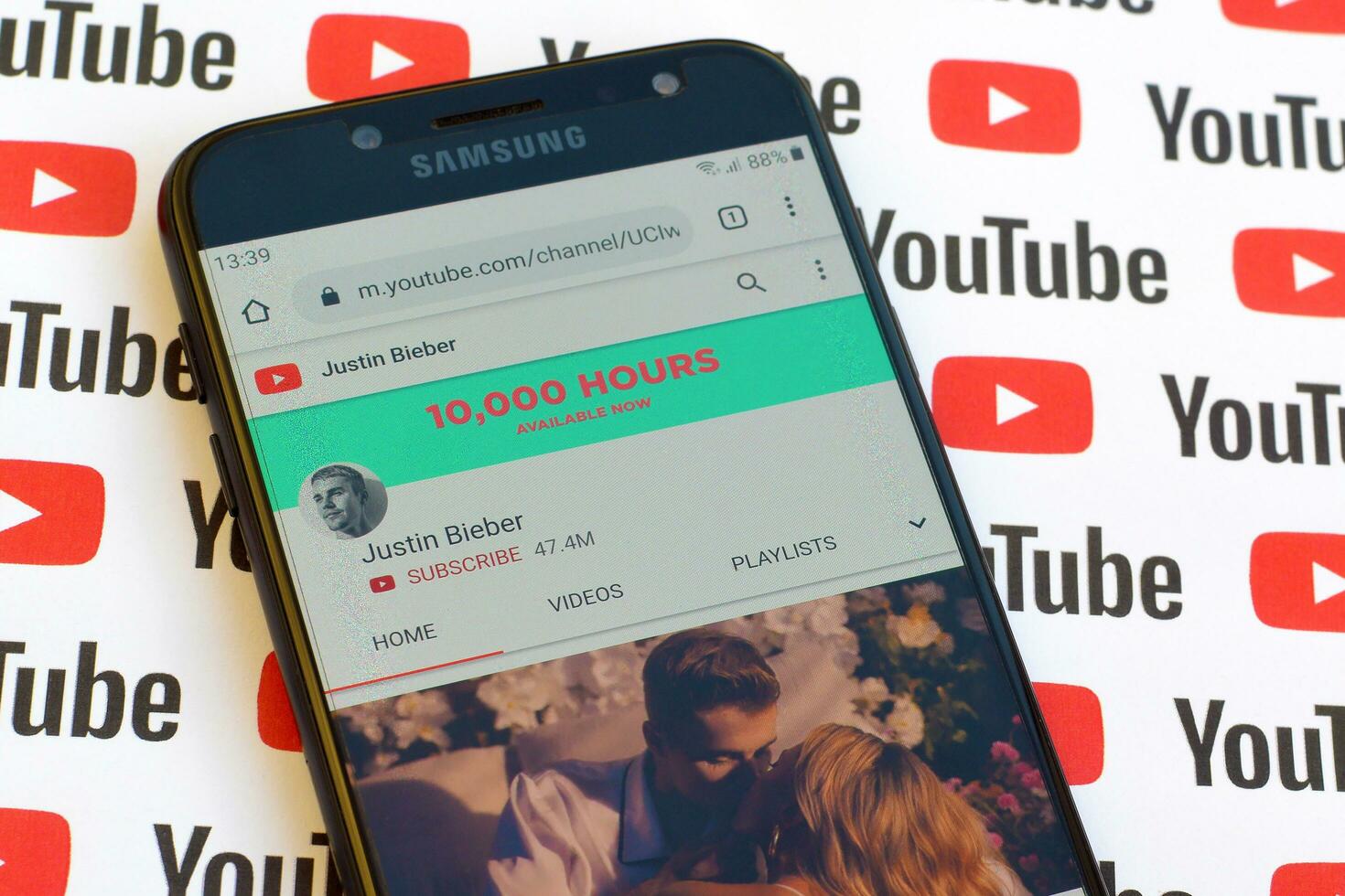 Justin Bieber official youtube channel on smartphone screen on paper youtube background. photo